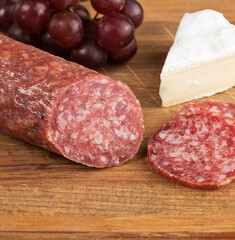 Brie Cheese And Salami On A Wooden Board