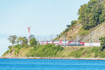 Passenger double deck train moves along Black sea coast. Sochi. Russia.