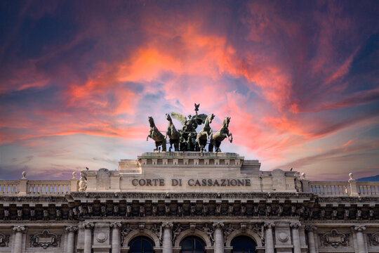 Pink dramatic skies during sunset over the bronze horses at corte di cassazione supreme court in Rome, italy.