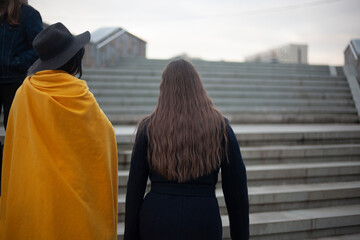 Girls walk up the stairs in the city.