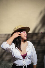 Cute girl plays with bubbles like a child. Beautiful woman with curly black hair have good time in the city at daytime
