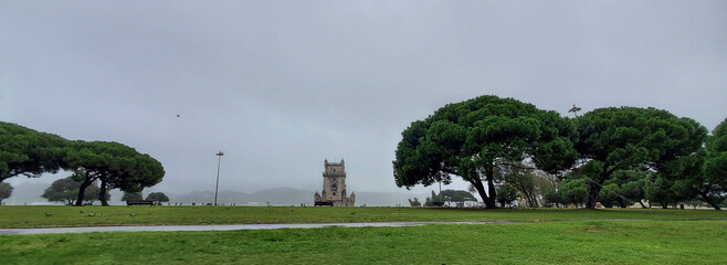 Fototapeta na wymiar The Belem Palace in between trees in rainy day.