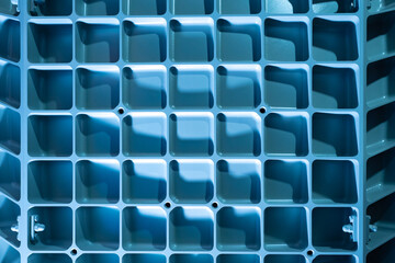 Obraz premium Industrial background. Light blue background with metal lattice. Metal latticeon industrial equipment. Abstract industrial texture. Metal lattice on production machine. Background on theme production