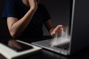 Fototapeta na wymiar Woman using laptop with chart hologram effect.