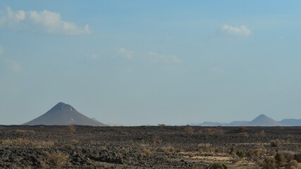 Fototapeta na wymiar Mountains and volcanoes on the horizon, between Jeddah and Medina, Saudi Arabia