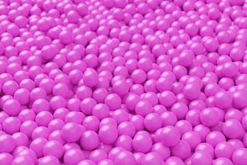 Ball pool or pit filled with pink plastic balls, abstract texture background, selective focus