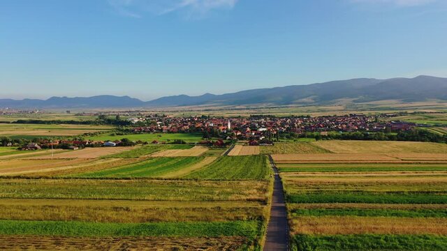 Flying towards Sancraieni, idyllic European village among farmland, Romania