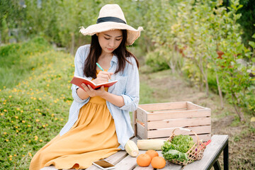 Obraz premium Farmer merchant woman doing Income statement from selling vegetables and fruits.