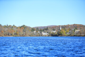 Fototapeta na wymiar Trees in autumn colors reflect surrounding Lake Gleneida in Putnam County, New York.