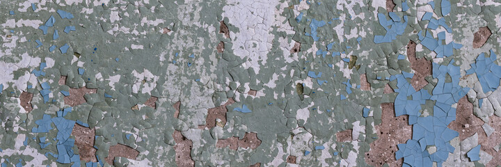 Peeling paint on the wall. Panorama of a concrete wall with old cracked flaking paint. Weathered rough painted surface with patterns of cracks and peeling. Wide panoramic grunge texture for background