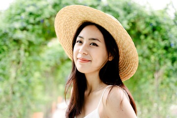 Close up portrait of asian traveler woman wear hat outdoors at park.