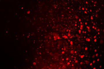 Red glitter lights abstract background. Defocused bokeh on dark or black background.