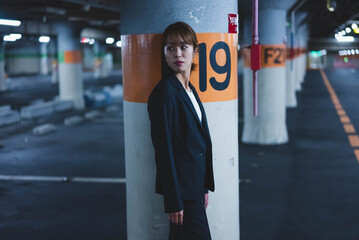 夜の街にいるスーツの女性