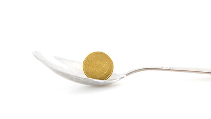 A spoon and a euro coin in a spoon on a white background