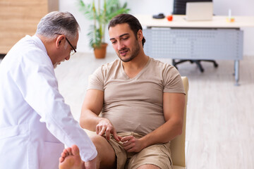 Experienced doctor traumatologist examining young male patient