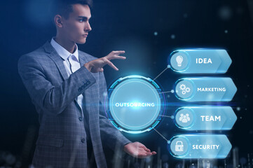Business, Technology, Internet and network concept. Young businessman working on a virtual screen of the future and sees the inscription: Outsourcing
