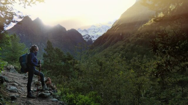 Woman hiking in in the forest valley of the Himalayan mountains, overlooking on the mount Thamserku summit