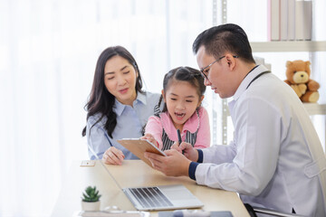 Pediatrician doctor describes the results of a physical examination to children and  mother holding baby in her hands.