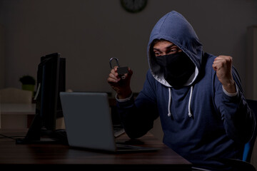Male hacker hacking security firewall late in office