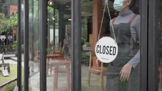 Asian woman wearing mask shopkeepers reopened after hard times during the covid-19 epidemic.