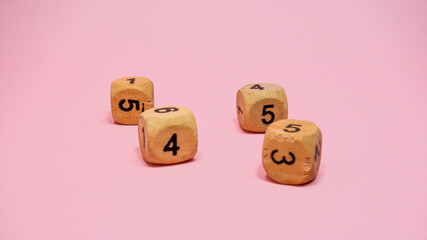 Wooden dice on pink background