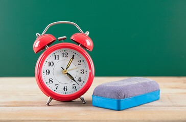 Teaching a red alarm clock and a blackboard eraser in front of the blackboard