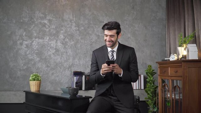 Footage B roll A Cheerful guy is working in office making mobile phone call and using laptop taking notes in notebook. Business communication. Work from home , business technology concept. 