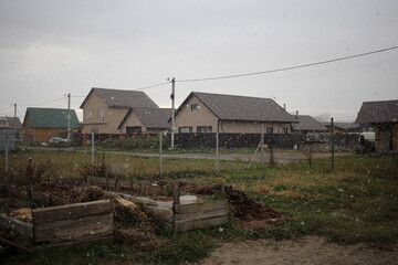 Fototapeta premium snow on garden beds in houses weather in autumn