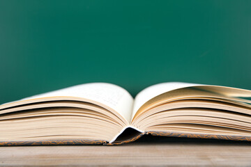 A book opened in front of the teaching blackboard