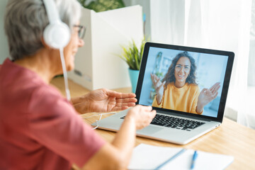 Senior woman is using laptop for conversation with daughter