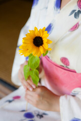 向日葵を持った浴衣の女性