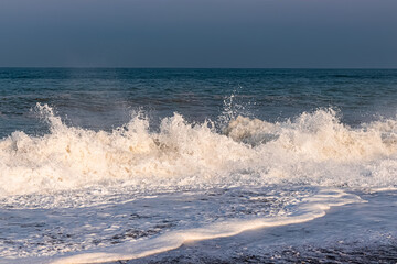 Splashes and foam of sea waves on the seashore