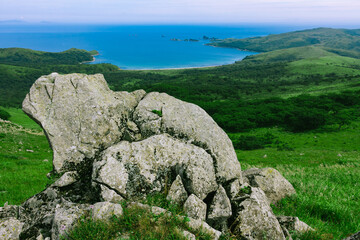 Large rocks on top of the hill, summer sea background.