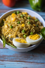 Slices of boiled egg on a bowl of noodles on a background