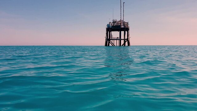 Low angle approach of offshore oil platform or gasoline rig in open ocean