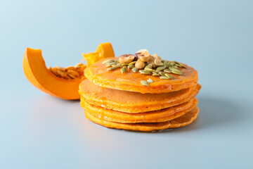 Tasty pumpkin pancakes on grey background