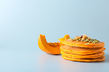 Tasty pumpkin pancakes on grey background