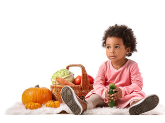 Fototapeta premium Cute African-American baby girl with harvest in basket on white background
