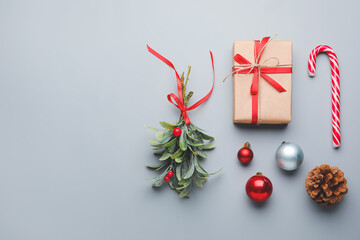 Christmas composition with mistletoe branch and decor on grey background