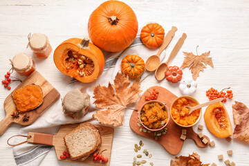 Autumn composition with tasty pumpkin jam on white wooden background