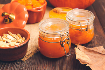 Jars of tasty pumpkin jam on table