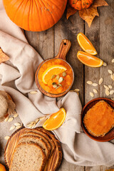 Tasty pumpkin jam with bread on wooden background