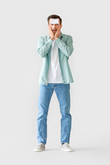 Fototapeta premium Confused man with blank note paper on his forehead against grey background