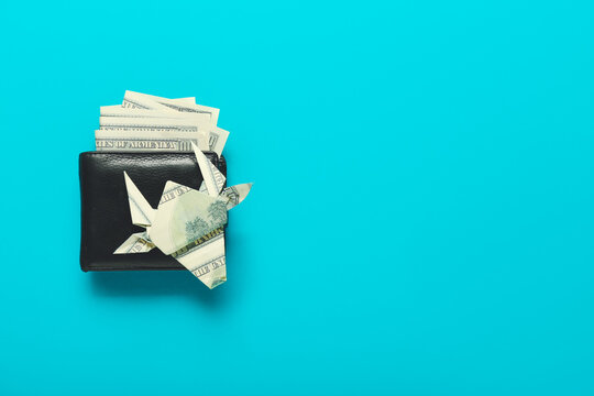 Wallet With Money And Origami Bull On Color Background