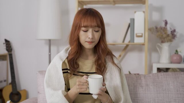 front view of Asian young lady lack of energy drinking lukewarm water, feeling tired and dizzy.