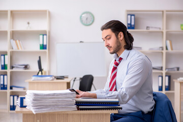 Fototapeta premium Young male employee unhappy with excessive work