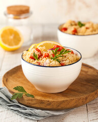 Tabouleh is an Arabic vegetarian salad made with couscous, tomatoes, parsley. Healthy lunch on a wooden background.