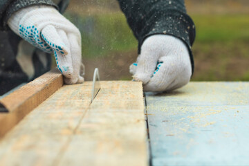 Daylight. machine for sawing wood. The master hands the board. Close-up.
