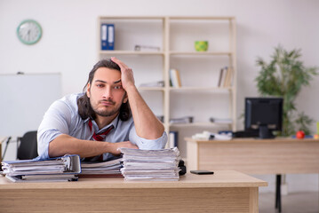 Fototapeta na wymiar Young male employee unhappy with excessive work