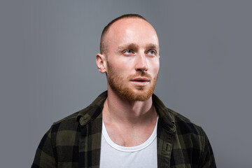 Stylish guy standing in shirt against gray.